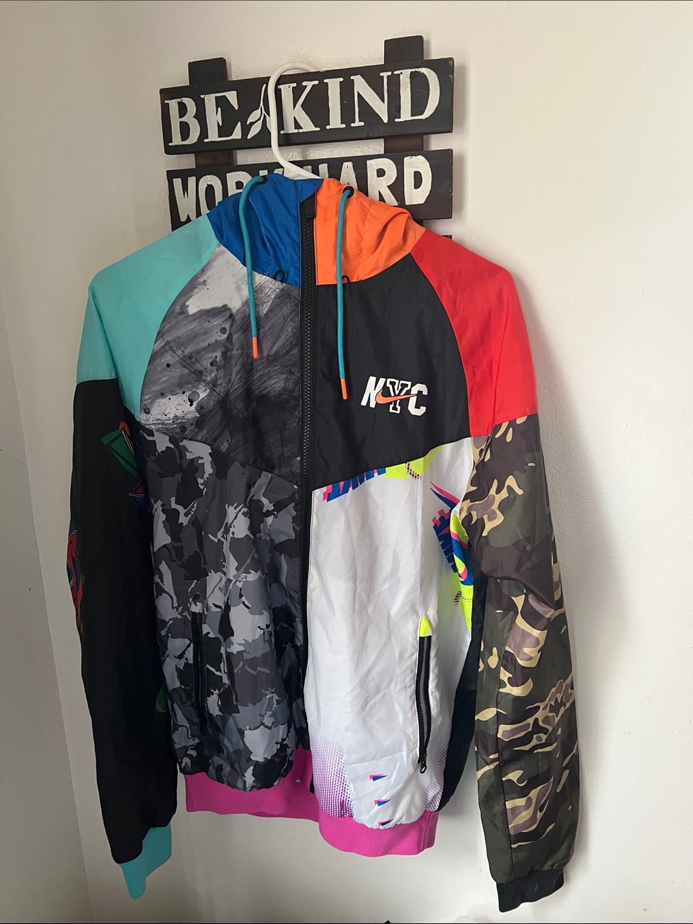 Nike Multicolor NYC Patchwork Windbreaker Jacket and Black Nike sweater.